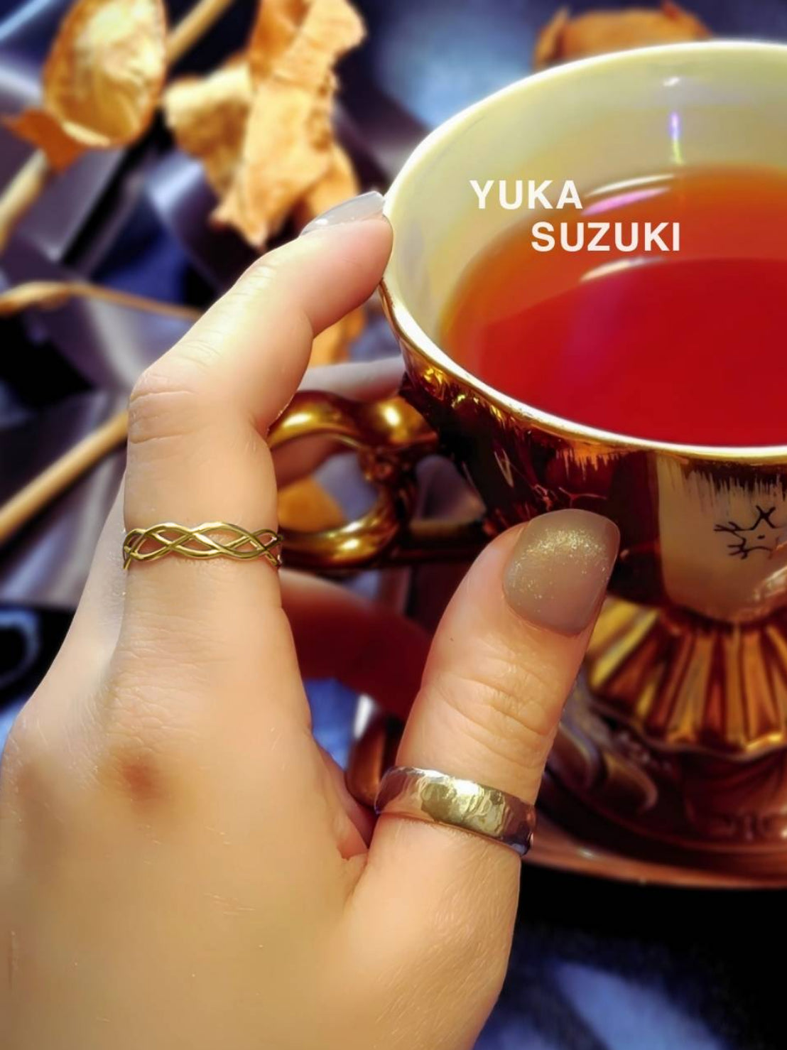 編込み風のゴールドの指輪を指に着けた画像