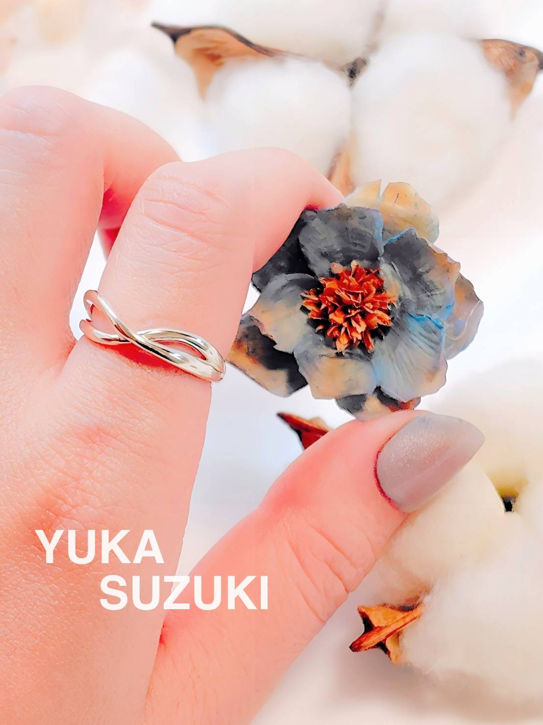 クロスしたシルバーの指輪を指に着けた画像