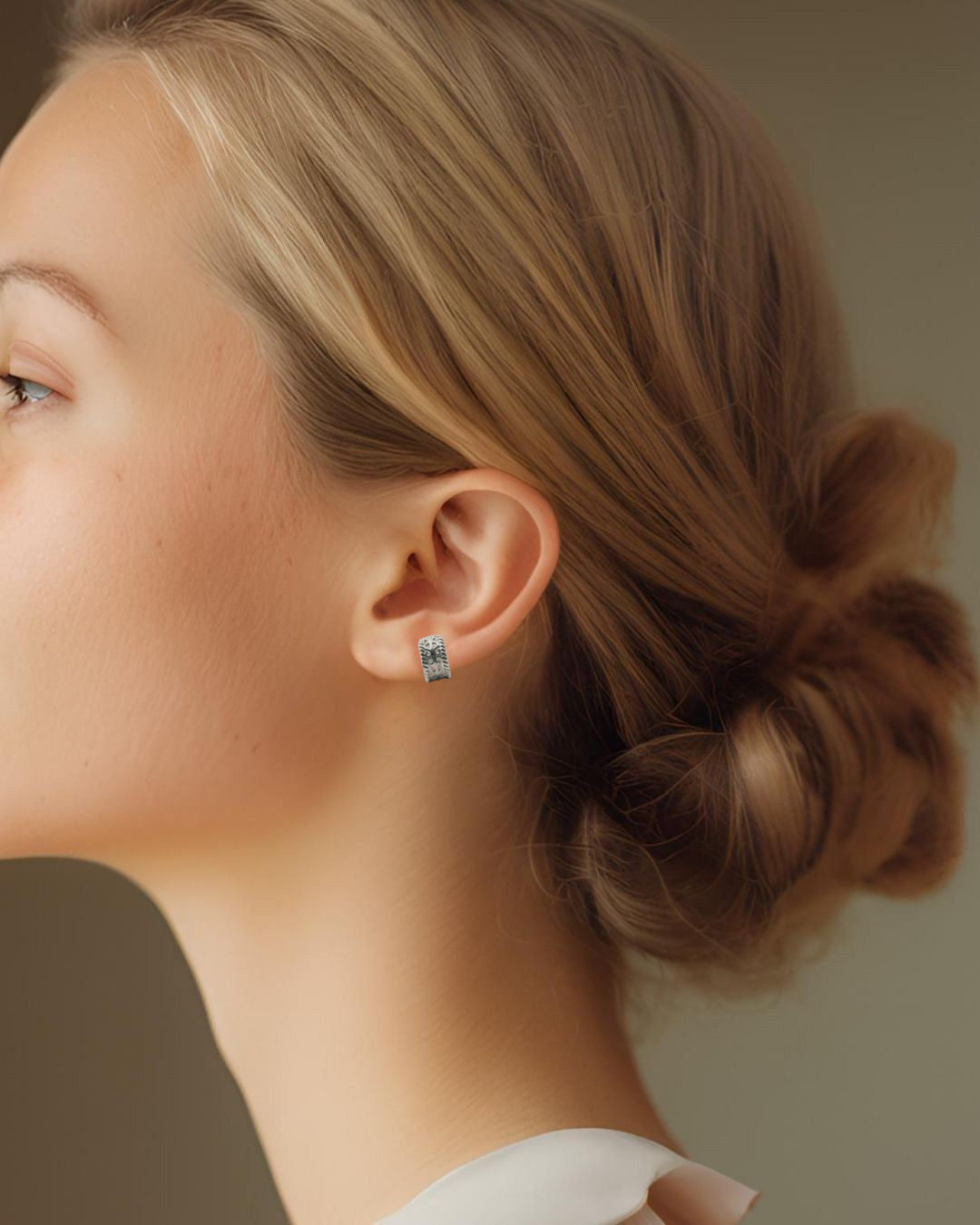 透かし模様のプラチナのイヤカフを着けた女性